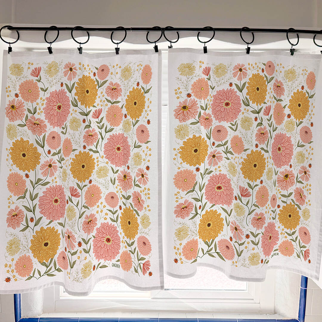 Floral patterned curtains hanging on a rod with a window in the background.