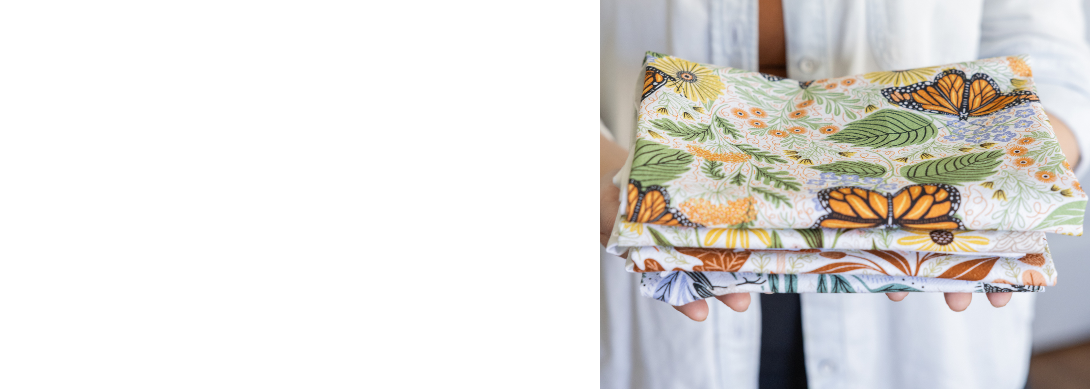 Woman holding a stack of delightfully soft flour sack cotton tea towels