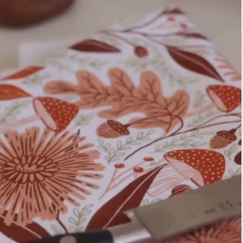 Video of a brown coffee cup being set on a fall towel