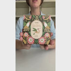 Glass cream-colored candle with green box and hummingbird illustration